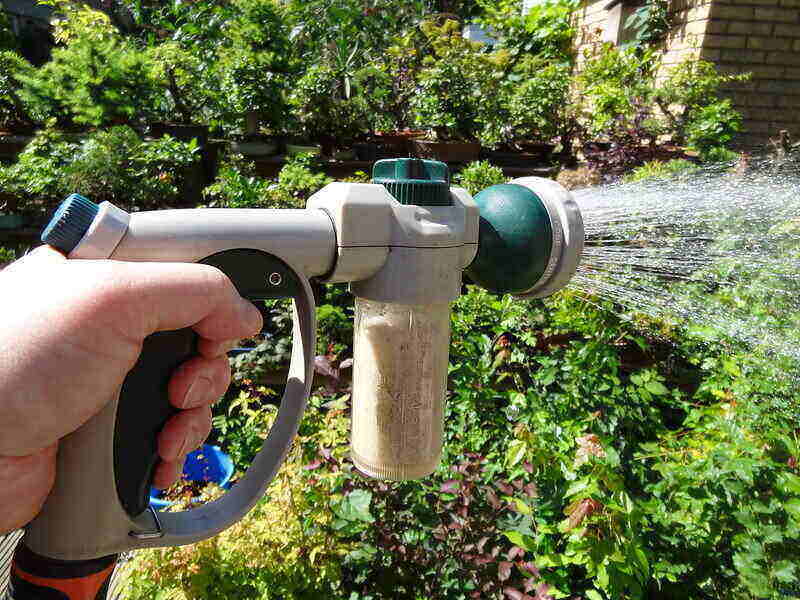 hand-held fertilizer sprayer being applied