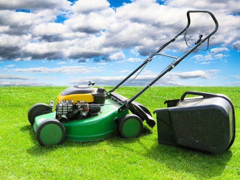 Lawn Mower on green grass with blue sky 