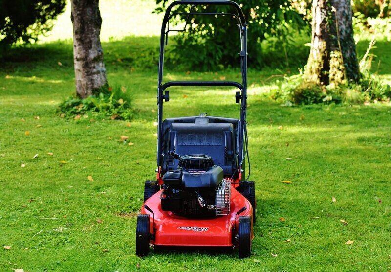 Red color lawn mover on the grass 