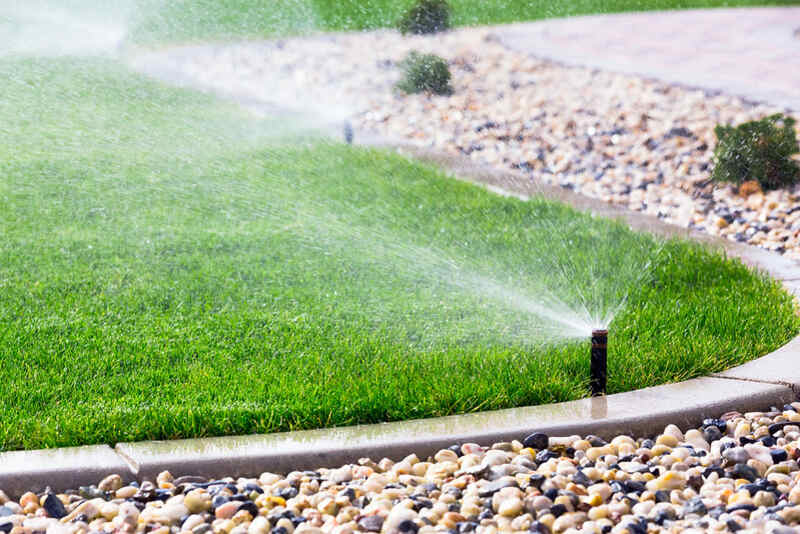 A lawn being watered using sprinklers