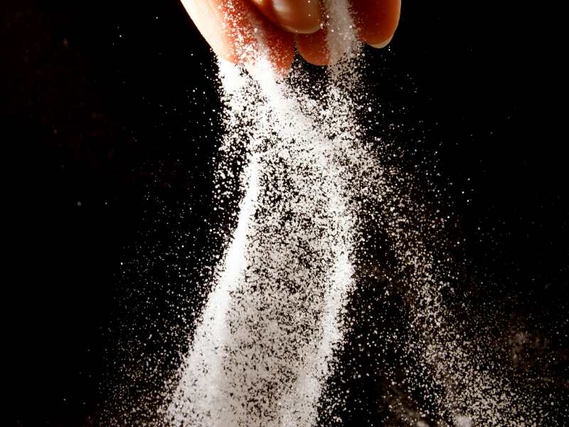 salt being poured from someones fingers